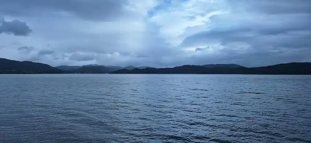 open fjord water under a heavy sky with distant mountains