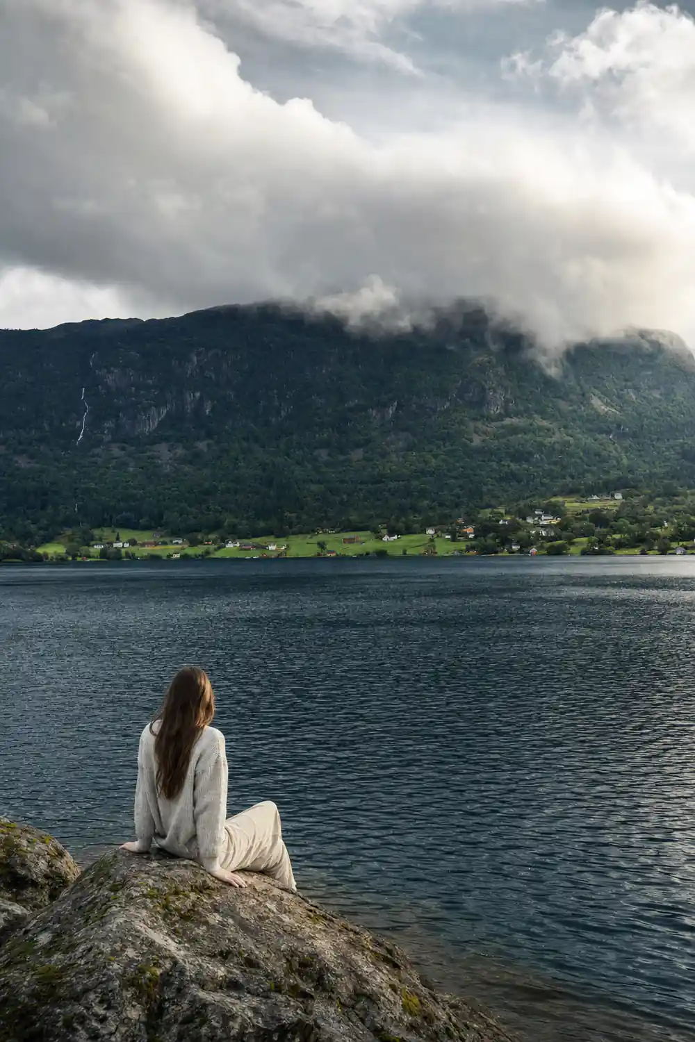a steep fjord wall with cloud sitting halfway down it